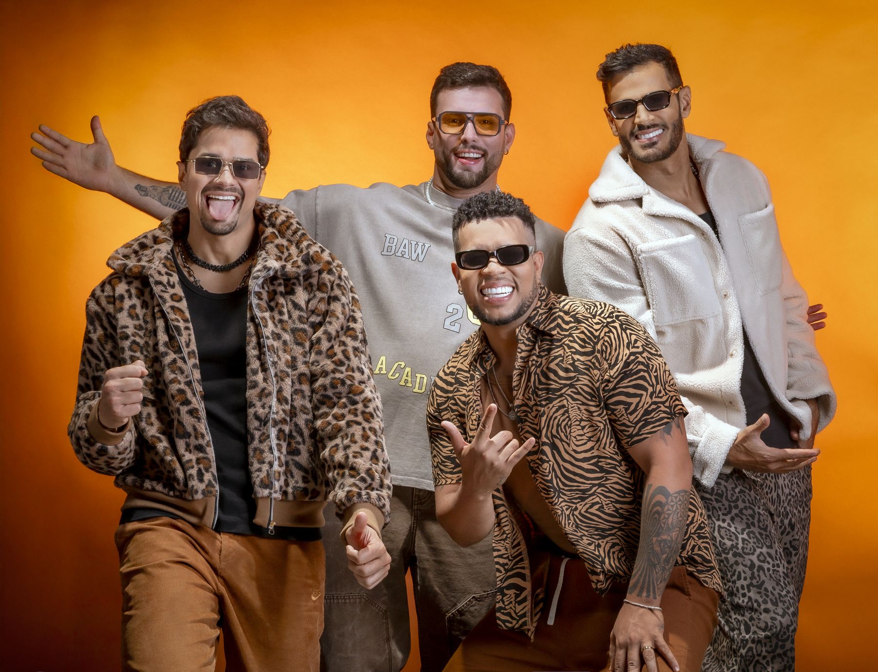 Os quatro integrantes do Deu Samba sorrindo em fundo laranja