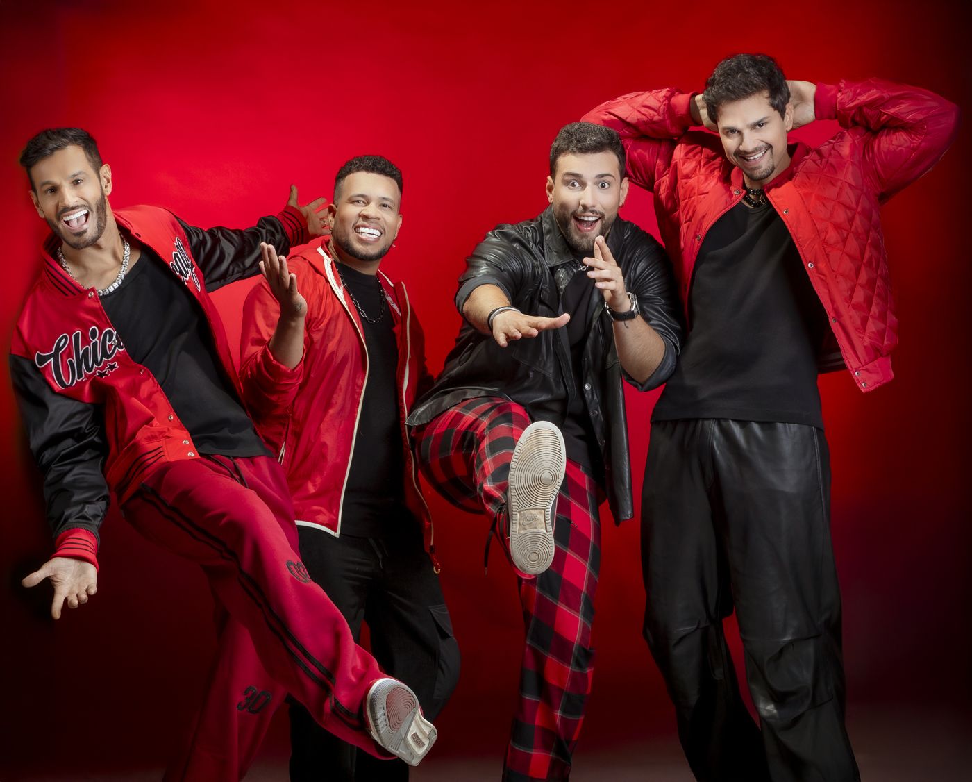 Banda em fundo vermelho, um integrante chutando para o alto