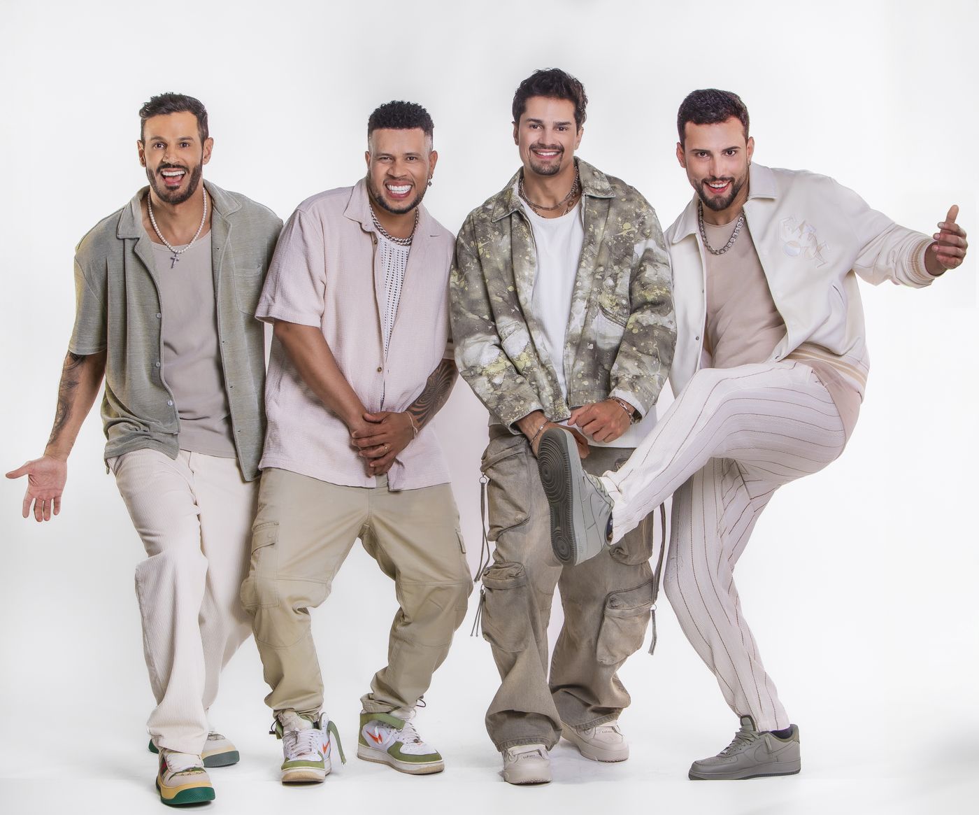 Banda em roupas claras, um integrante com a perna levantada