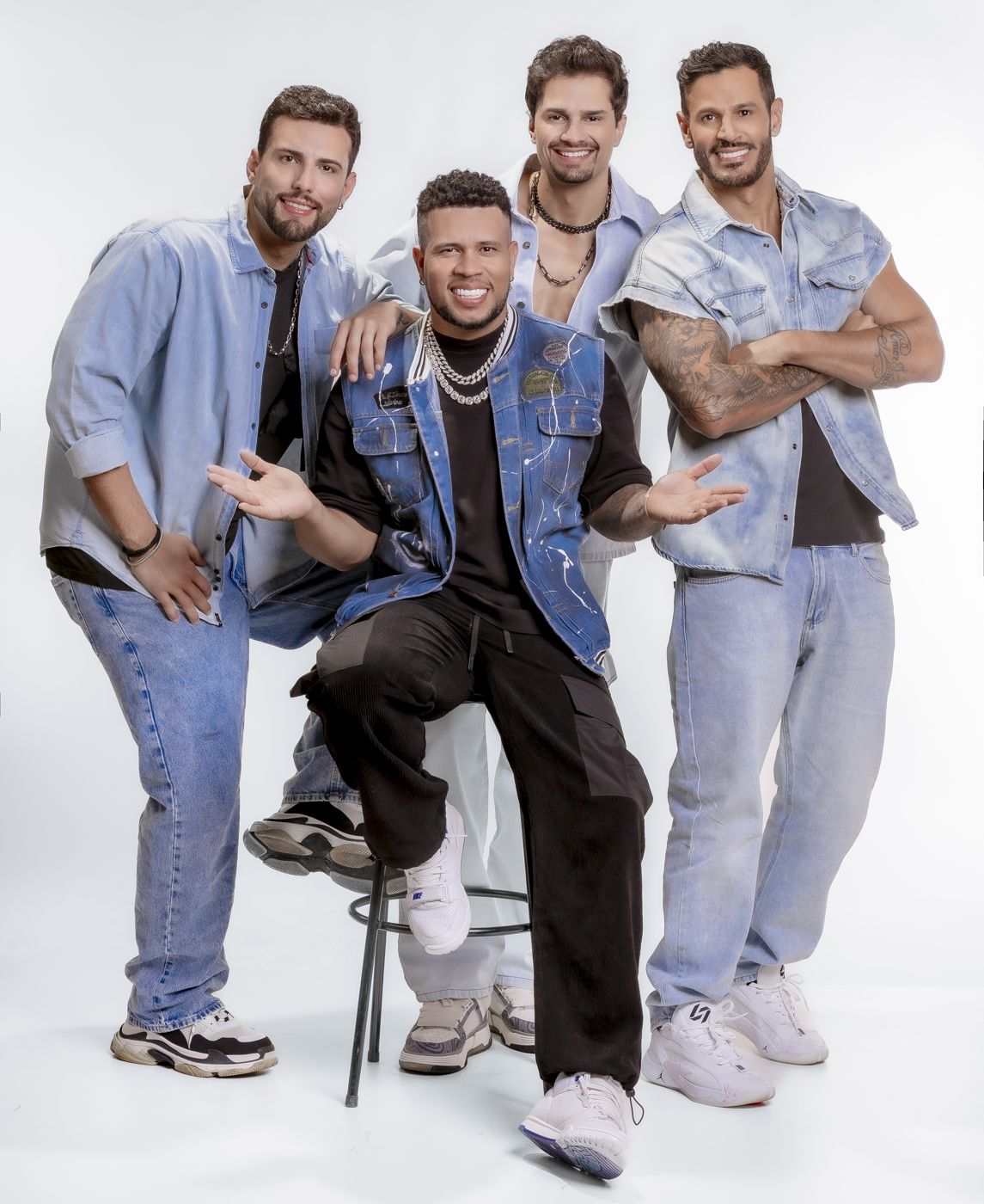 Banda em jeans, um integrante sentado no banco