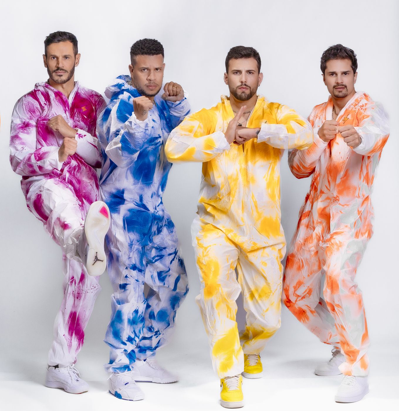 Banda de macacões coloridos em pose de luta